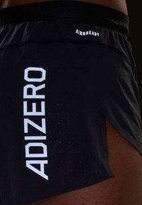 Melni sporta šorti ar perforētu tekstūru, ar baltu "ADIZERO" logotipu sānos un "AEROREADY" apzīmējumu pie jostas.