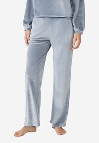 Conjunto de loungewear de terciopelo en azul claro, con textura acanalada, mangas largas y pantalones de corte holgado con diseño de pierna recta.