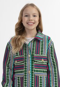 Värikäs kuviollinen takki, jossa on vihreitä, vaaleanpunaisia ja sinisiä raitoja. Valmistettu kankaasta, jossa on kaksi etutaskua ja kultaiset napit.