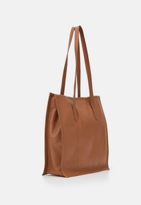 Borsa tote in pelle marrone con due manici lunghi, texture liscia, design strutturato e cuciture sottili lungo i lati. Nessun hardware visibile.