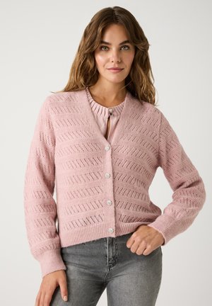 Helles rosa Strickjacke mit V-Ausschnitt und strukturiertem Muster. Verfügt über runde, blumige Knöpfe und lange Ärmel. Kombiniert mit grauen Jeans.