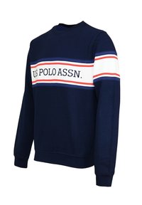 Námořnická modrá mikina s bílým a červeným vodorovným pruhem a nápisem "U.S. POLO ASSN." Vyrobena z měkké tkaniny, s pružnými manžetami a lemem.