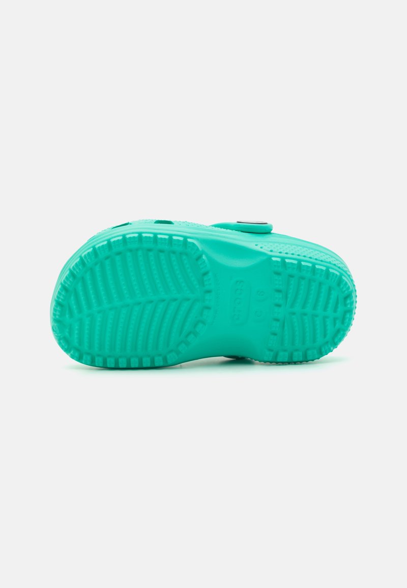 Suela de zapato de goma turquesa con patrón de agarre texturizado, detalle de logo circular y bordes moldeados para mejorar el soporte y la tracción.