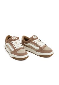 Brown and beige sneakers made of suede and mesh, featuring white laces, padded collar, and branding on the tongue and side panel.