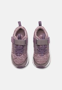 Lilla barnesneakers med teksturert stoff, justerbar Borrelåsrem, snøre detaljer og forsterket tåhette. Hvit såle står i kontrast til overdelen.