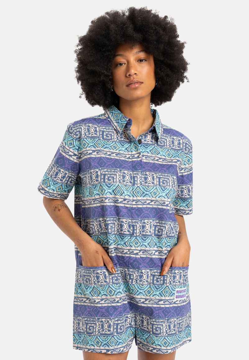 Colorful short-sleeve romper featuring a geometric pattern in shades of blue and purple, with a collared neckline and two front pockets.