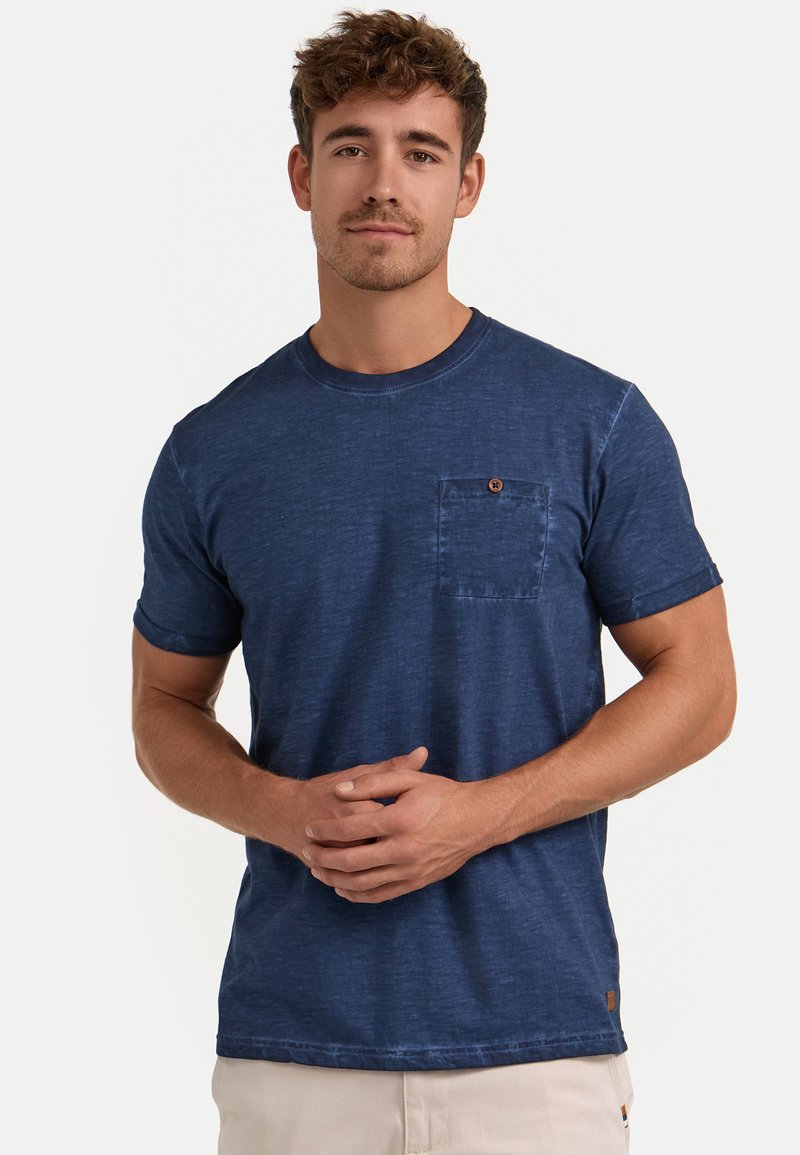 Blå crew-neck t-shirt lavet af tekstureret stof, med en brystlomme med knapdetalje. Korte ærmer og afslappet pasform.