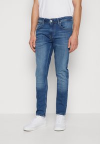 Jeans i medelblå tvätt, slim fit, med en klassisk femficksdesign, subtila blekningar och en dragkedja med enkel knappstängning.