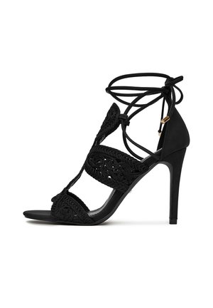 Sandalo nero con tacco alto, design ricamato intricato, punta aperta e cinturini alla caviglia regolabili con lacci. Texture liscia e tacco a punta.