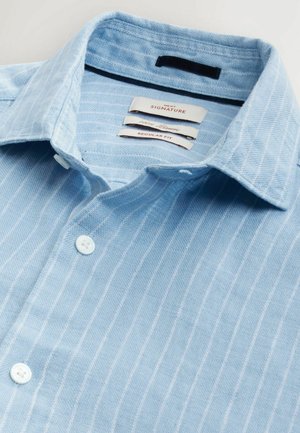 Lysblå linned skjorte med hvide lodrette striber, normal pasform, med en struktureret krave og fire hvide knapper.
