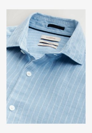Lysblå linned skjorte med hvide lodrette striber, normal pasform, med en struktureret krave og fire hvide knapper.
