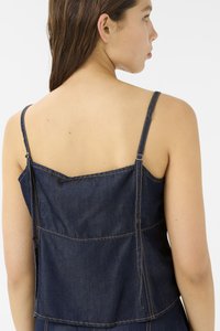 Top de denim con tirantes ajustables, color índigo oscuro, detalles de costura visibles y un diseño en capas que incluye un canesú en la parte posterior y bolsillos.