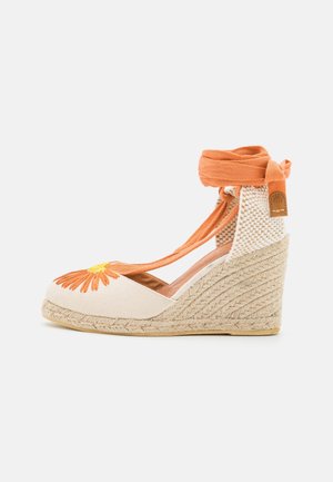 Zapato alpargata cuña con tacón trenzado beige, parte superior de lona con bordado floral naranja y tiras anaranjadas para atar al tobillo.