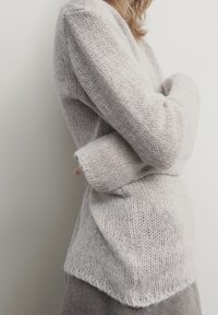Pull gris clair en maille avec un design ample et texturé, doté de manches longues et d'un ourlet légèrement plus long à l'arrière.