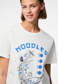 Camiseta de algodón blanca con un diseño gráfico azul que presenta la palabra "NOODLES" y ilustraciones de fideos, camarones y verduras.