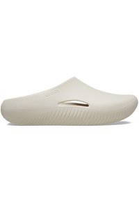 Beige Crocs Hausschuhe mit einer glatten, matten Oberfläche, die seitliche Aussparungen, eine dicke Sohle mit gerippter Textur und eine abgerundete Zehenpartie aufweisen.
