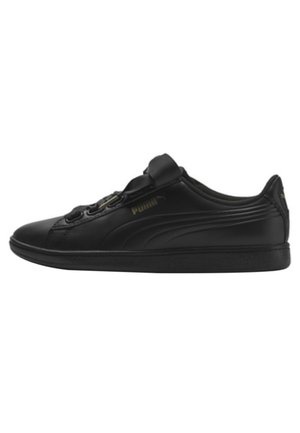 Czarny niskoprofilowy sneaker Puma z skórzaną cholewką, gładką podeszwą i subtelnymi, markowymi detalami w ciemnym złocie po boku i na pięcie.