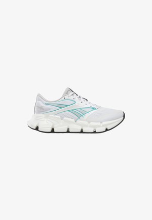 Zapatilla deportiva blanca con detalles turquesa, suela segmentada y gruesa, y parte superior de malla, mostrada de perfil lateral mirando hacia la derecha.