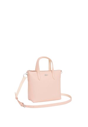 Petit sac à main en cuir texturé rose pâle avec deux poignées et une bandoulière longue détachable, arborant un logo crocodile argenté sur le devant.