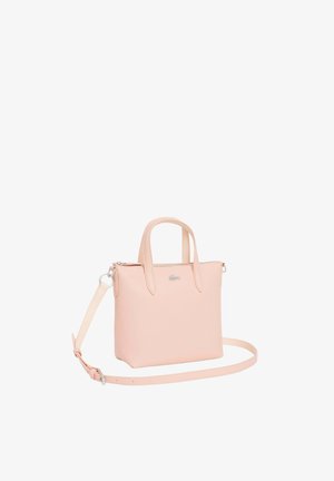 Petit sac à main en cuir texturé rose pâle avec deux poignées et une bandoulière longue détachable, arborant un logo crocodile argenté sur le devant.