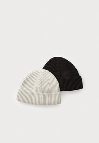 Two ribbed knit beanies: one in light gray and one in black. Feature folded cuffs and a seamless, rounded top.