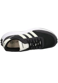 Svart och grå sneaker med tre vita ränder, material av mesh och mocka, rund tå och svarta snören. Har en texturerad sula.