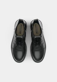 Zapatos de cuero negro con un acabado suave, que presentan una puntera redonda, diseño con cordones y un collar acolchado para mayor comodidad.