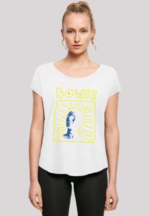 White short-sleeve shirt featuring a blue graphic of a face with yellow text “BOWIE” and radiating lines. Soft, lightweight fabric.