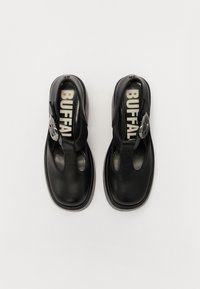 Mustad mustad nahast kingad avatud varbaga ja kandmiskonksuga disainiga. Omab silmapaistvat pandlat ja tekstuuriga sisetaldadega, millel on "BUFFAL" bränd.