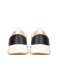 Vista trasera de zapatillas que presentan un talón de cuero negro, parte superior de malla beige, mediopie blanca y suela de goma naranja con una lengüeta.