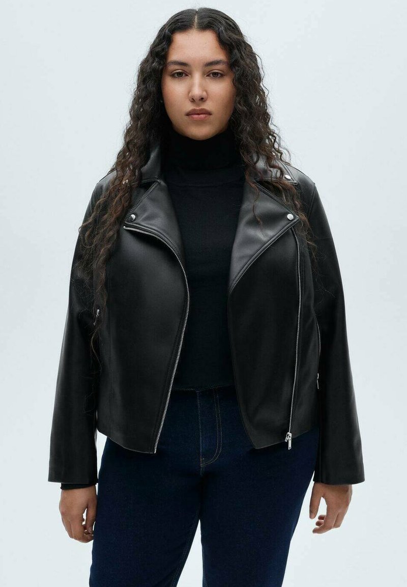 Black leather jacket with a structured collar, zip closure, and two side pockets. Worn over a black turtleneck, paired with dark jeans.