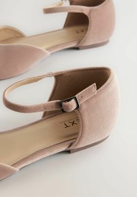 Rosa Wildlederballetts mit einer runden Zehenpartie, Knöchelriemen und einer kleinen schwarzen Schnalle. Das Design zeichnet sich durch eine glatte Textur und einen niedrigen Absatz aus.