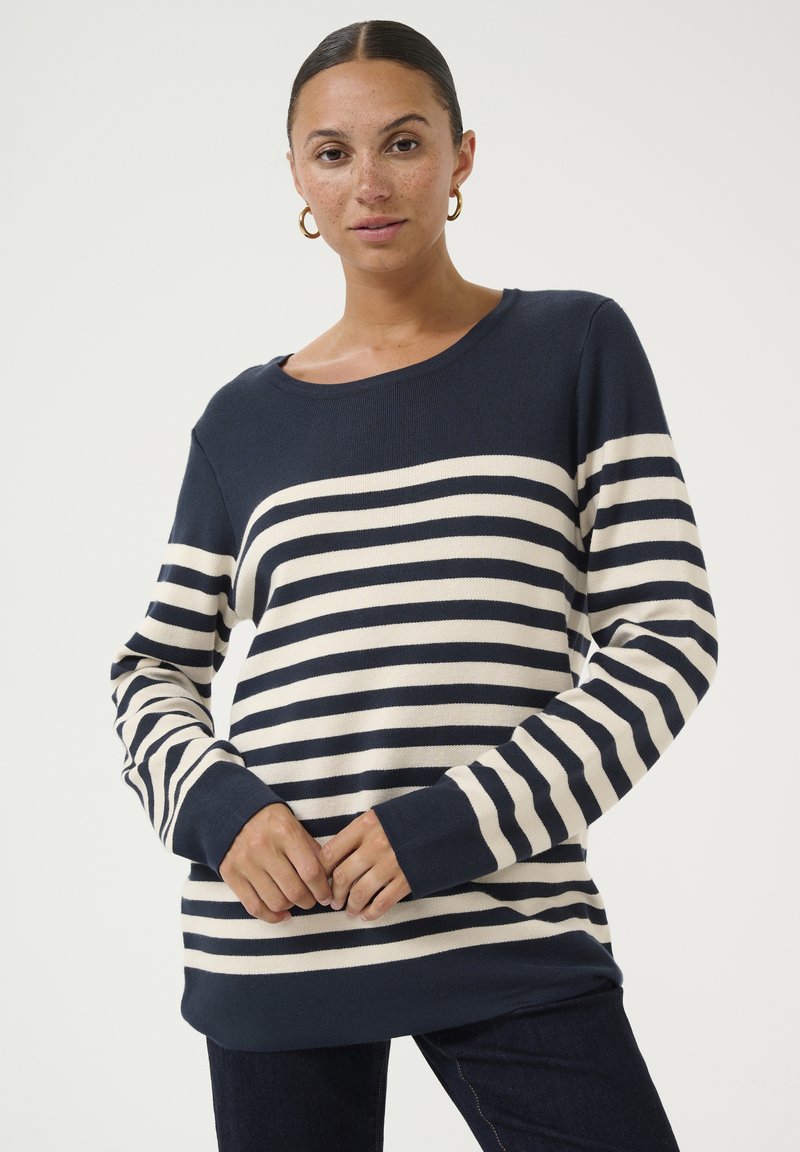 Jūras spēku un krējuma svītrains puloveris ar brīvu piegriezumu, apaļu kakla izgriezumu un garām piedurknēm, ar ribotas aproces un apakšmalu.