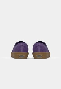 Lila mockaläder sneakers med låg profil och tanfärgad gummisula. Har vadderad krage, kontrasterande sömmar och logotyp på hälen.