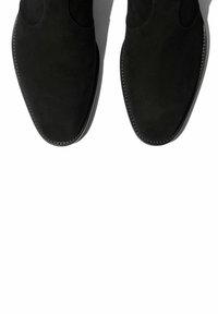 Botines de ante negros con un diseño elegante, puntera puntiaguda y costuras sutiles a lo largo de la suela, que muestran una textura suave y mate.