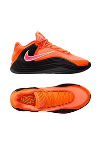 Scarpe da ginnastica Nike con tomaia di un arancione brillante, suola nera, accenti rosa e gialli, materiale testurizzato e design atletico moderno.