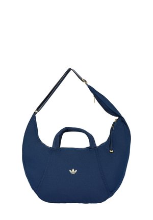 Sac à bandoulière en forme de croissant Adidas bleu marine avec poignées courtes, sangle ajustable et détails de fermeture éclair dorés.