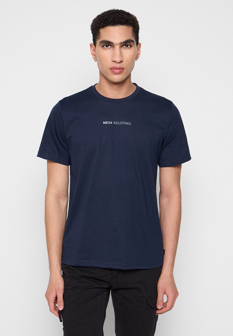 Marineblauwe katoenen T-shirt met een ronde hals, korte mouwen en het "MEXX INDUSTRIES" logo in het wit over de borst. Zachte textuur.