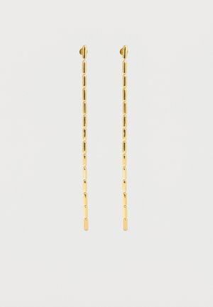 Lange, tynde øreringe af guldkæde med rektangulære led på en ensartet lys grå baggrund.