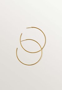 Pendientes de aro dorados con un diseño circular delgado. Cada pendiente presenta una superficie elegante y un mecanismo de cierre seguro.