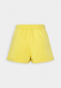 Shorts en coton jaune avec une taille élastique, une coupe décontractée et un ourlet roulé, présentant une texture lisse et un design minimaliste.
