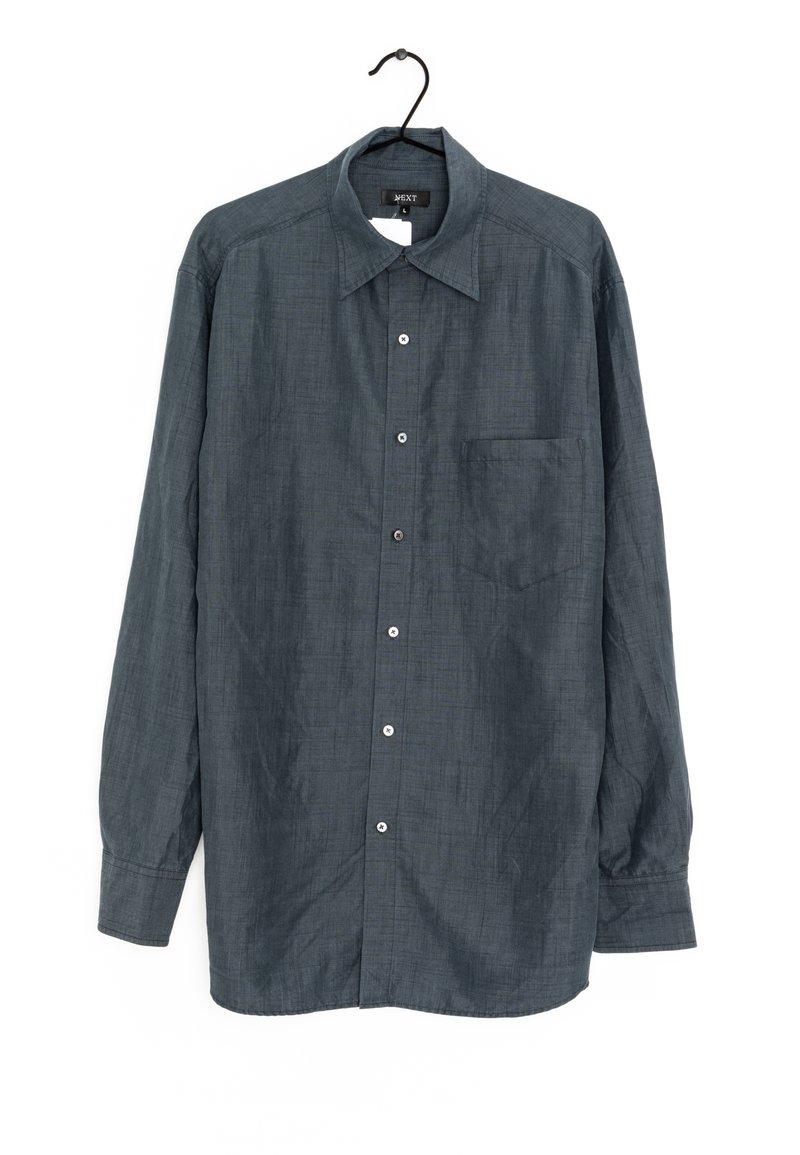 Camisa de manga larga en gris oscuro con botones, hecha de una tela texturizada, que presenta un cuello clásico, un bolsillo en el pecho y botones plateados.