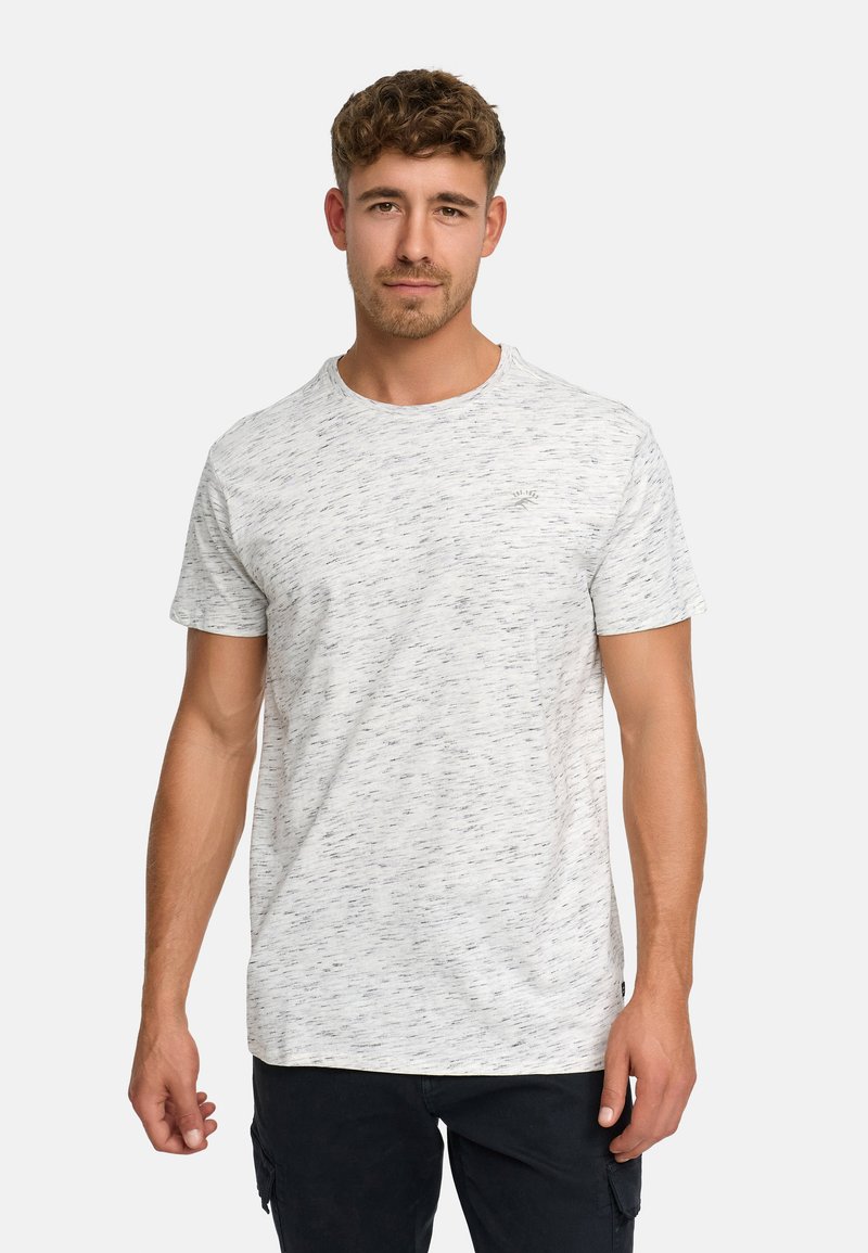 T-shirt blanc à manches courtes avec une texture chinée, présentant de subtils éclats bleus et gris. Encolure ronde et un petit logo.