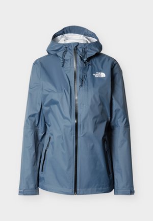 Μπλε αδιάβροχο μπουφάν The North Face με κουκούλα, εμπρόσθιο φερμουάρ, τσέπη στο στήθος και δύο πλαϊνές τσέπες με φερμουάρ, εμφανίζεται σε λευκό φόντο.