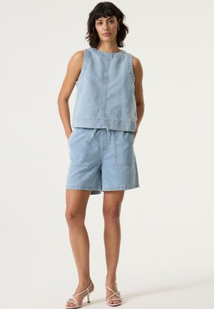 Lichtblauw denim mouwloos top met een ronde halslijn, gecombineerd met bijpassende denim shorts met twee voorzakken en een taille met trekkoord.