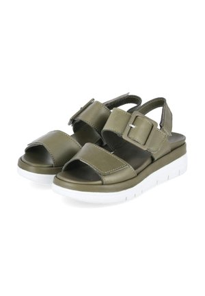 Olijfgroene open-toes sandalen met verstelbare bandjes en gespen, met witte plateauzolen voor extra hoogte en comfort.