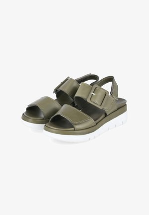 Olijfgroene open-toes sandalen met verstelbare bandjes en gespen, met witte plateauzolen voor extra hoogte en comfort.