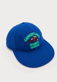 Modrá baseballová čiapka s vyšitým textom "CARHARTT WIP" a kreslenou postavičkou. Má zakrivený šilt a dizajn so šiestimi panelmi.