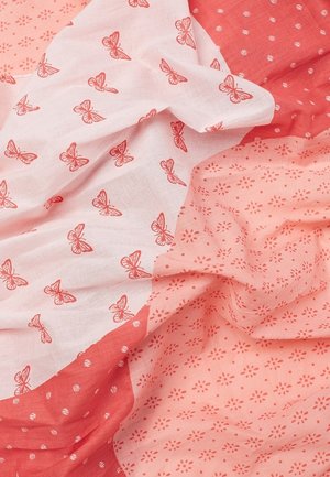 Tissu rouge et rose avec des motifs de papillons et de fleurs, drapé délicatement pour montrer la texture et les détails du design.