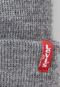 Gray knit fabric with a smooth texture, featuring a red Levi's label sewn into the side for brand identification.